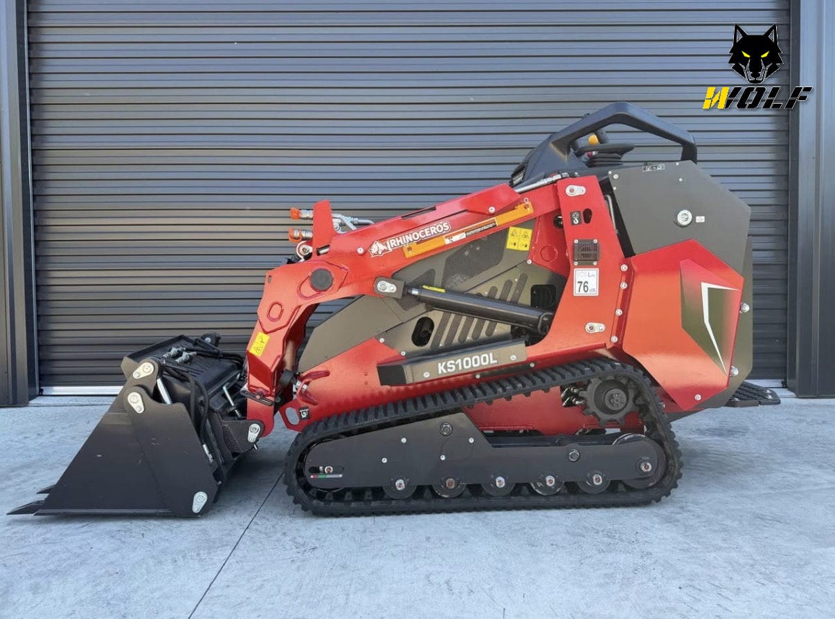 Rhinoceros KS1000L tracked mini loader, side profile, Wolf Mini Loaders mark in the top-right — wet hire with operator